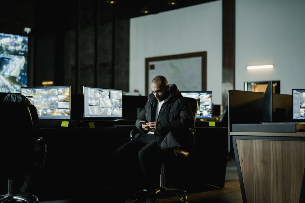 Office manager reviewing live CCTV security system footage on a desktop monitor