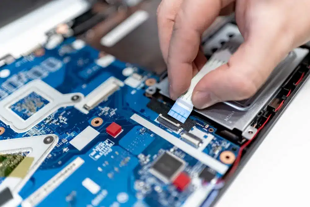 IT technician repairing a laptop on-site under an annual IT maintenance contract