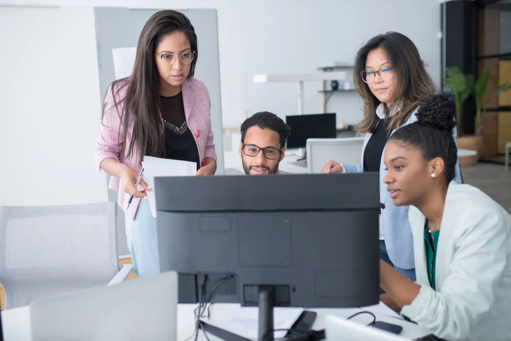 Small business team working on computers supported by managed IT services in Dubai