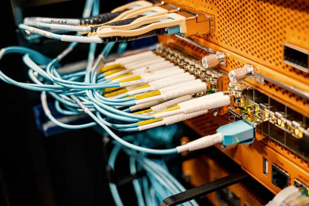 IT engineer configuring a network rack and firewall in a small business office in Mirdif