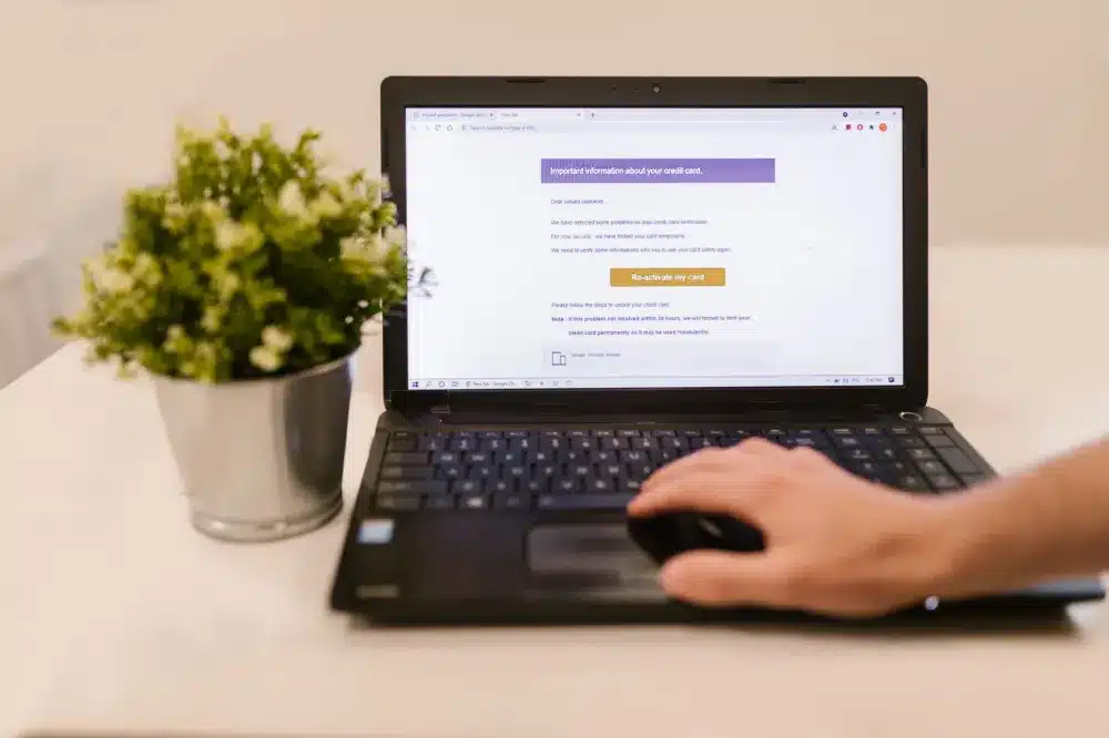 Business owner viewing a phishing email warning on a laptop screen highlighting cybersecurity risks