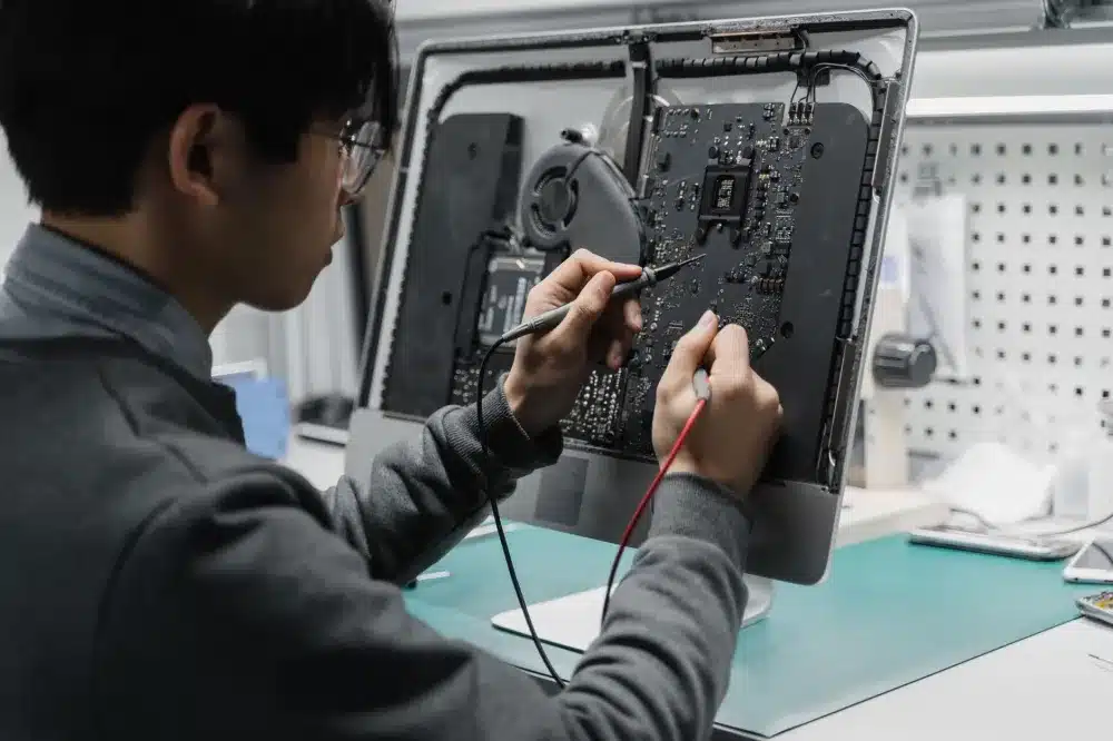 IT technician performing scheduled laptop maintenance at an Al Quoz business office