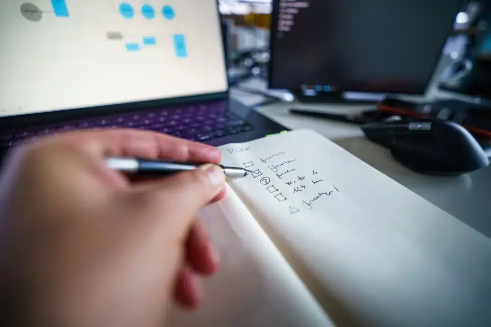 Business professional reviewing a cybersecurity checklist on a laptop in an office